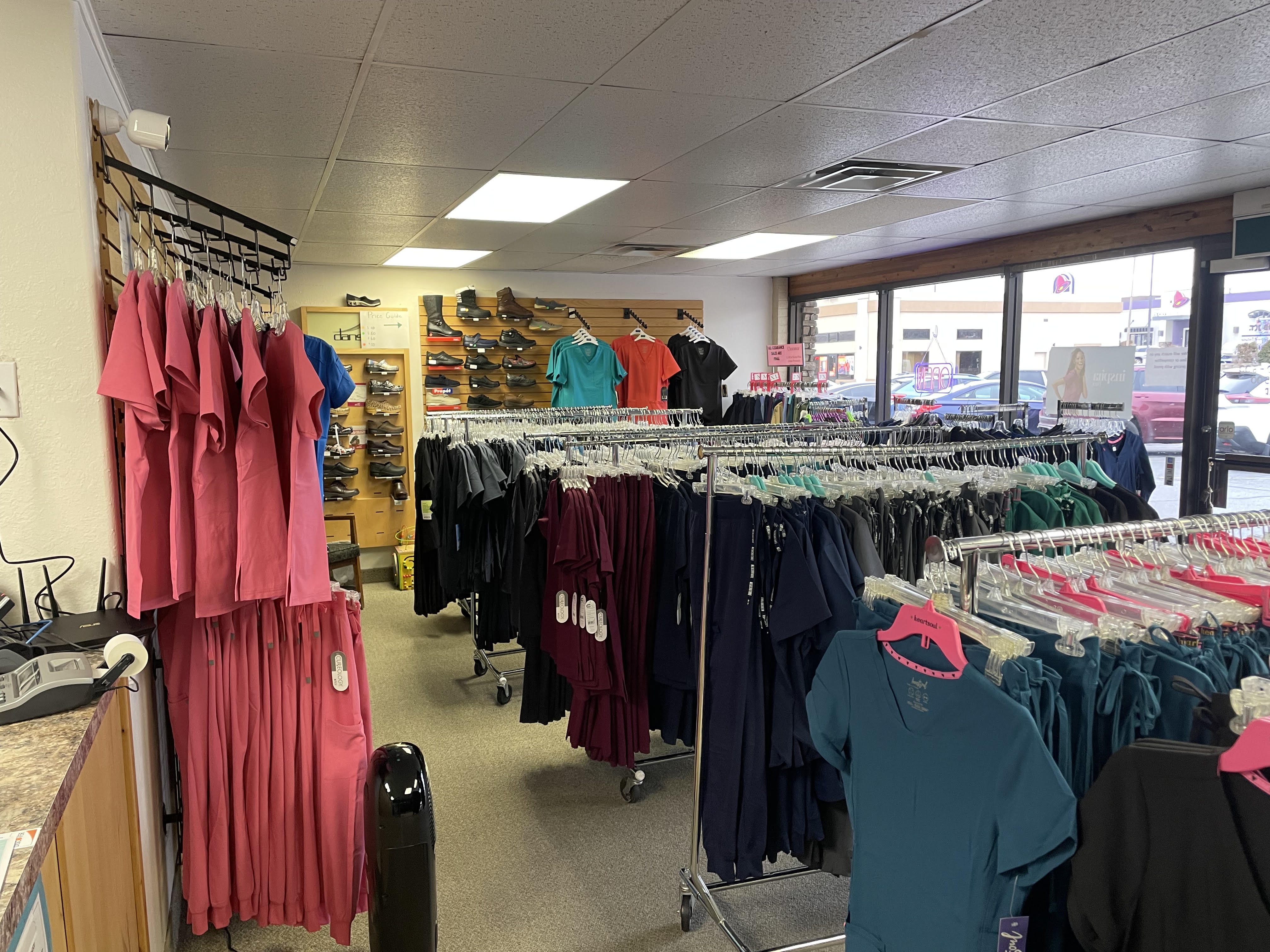 Scrub JCT sales floor with rounders of scrubs and a wall of professional footwear