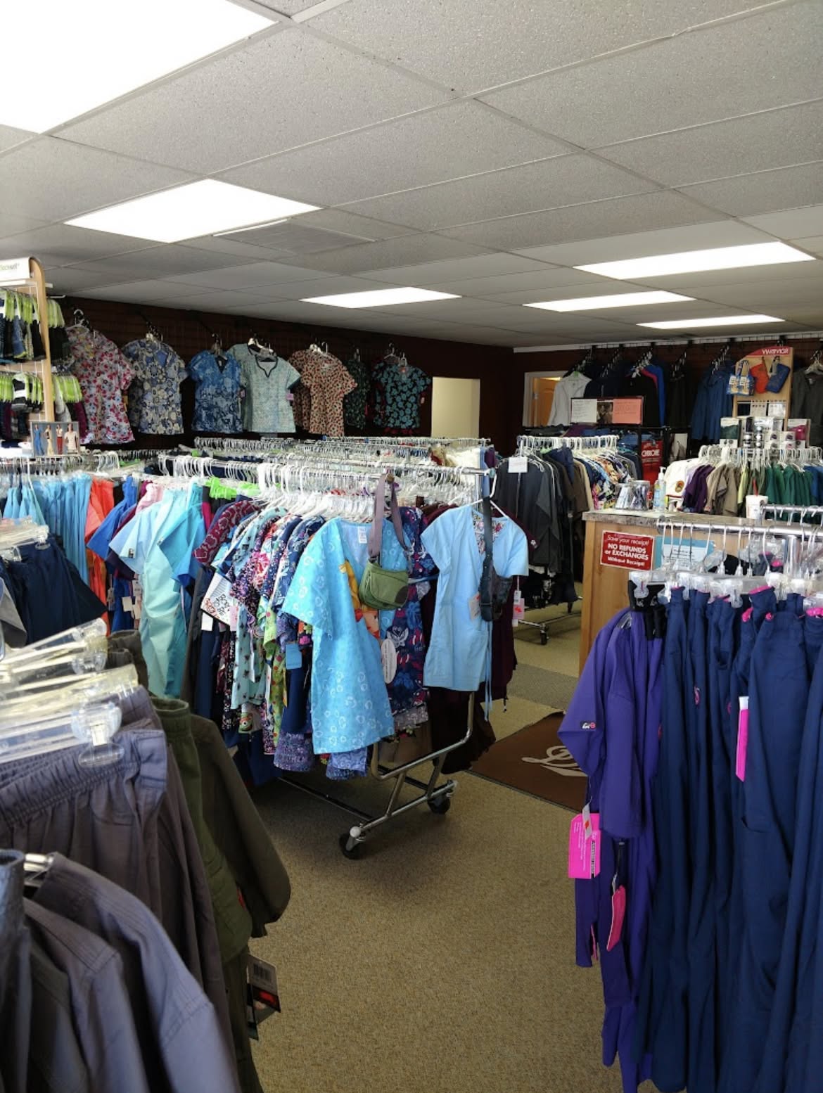 Inside the Scrub JCT store in Pocatello, showing racks of colorful medical scrubs and apparel